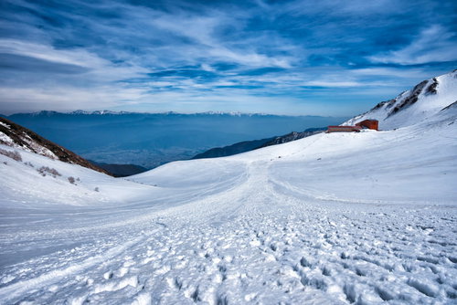 雪に覆われた千畳敷カールと山小屋の冬山風景
