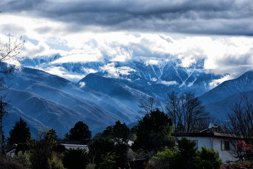 雲間から姿を現す後立山連峰の飛騨山脈、北アルプスの雪を頂いた峰々