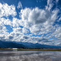 安曇野市の水田に映り込む青空と白い雲の水鏡風景の写真