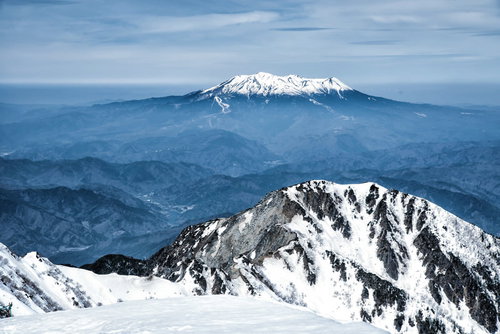 薄雲から頭を出す御嶽山と木曽前岳の雪山景観