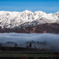 雲海にのまれる麓の村と白馬三山の朝焼け、朝の風景の写真