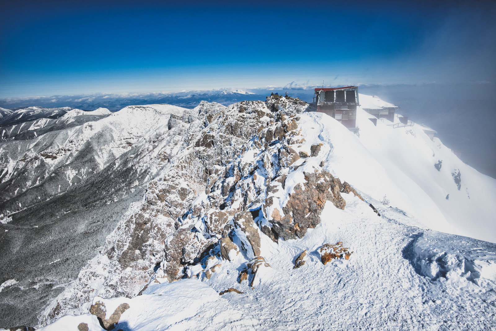 雪に覆われた八ヶ岳連峰赤岳の山頂付近、岩壁と山小屋が見える厳冬期の山岳風景
