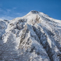 北アルプス中岳北面の岩壁に伸びる影と雪景色の写真