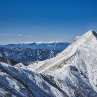 遥か彼方に見える残雪の中央アルプスの稜線の写真