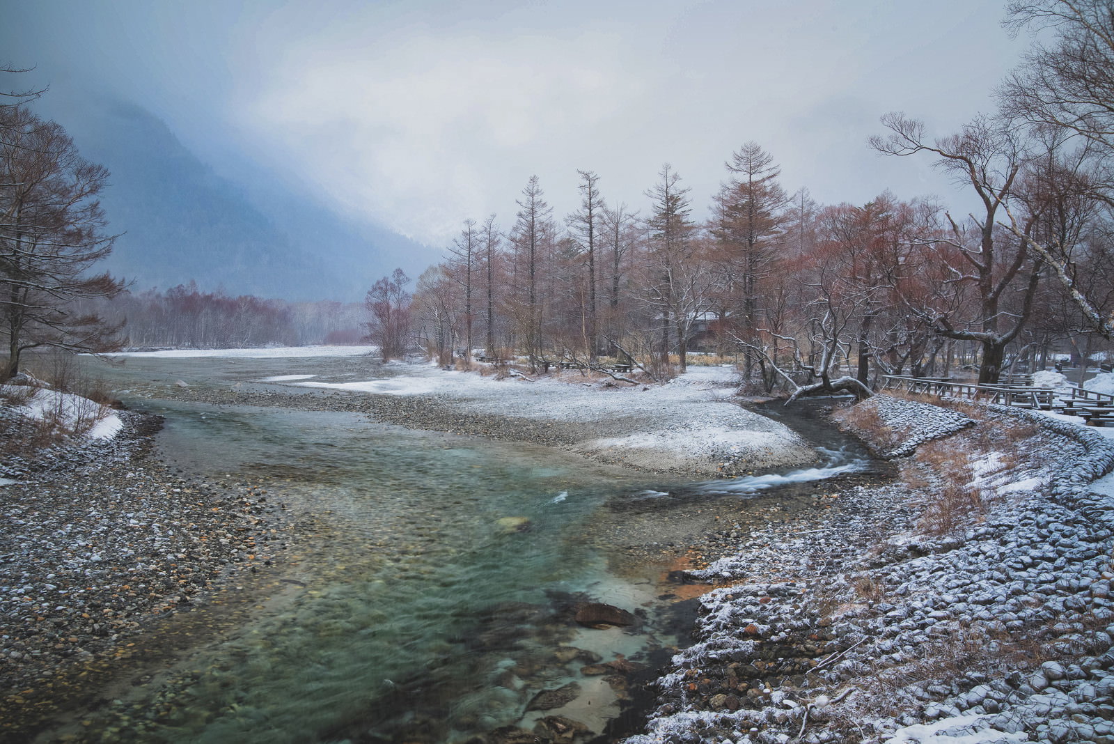 雪に覆われた上高地の川と雪山の冬景色