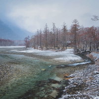 上高地の川を彩る雪化粧の冬景色の写真