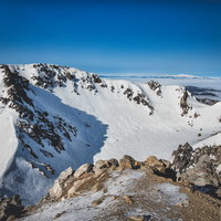 冬の焼岳の火口、雪に覆われた北アルプスの山頂の写真