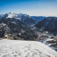 焼岳山頂から眺める穂高方面の雪景色と北アルプスの山並みの写真