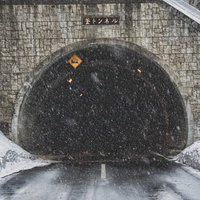 不気味に口を開ける釜トンネル、雪道に続く長野県の山越え道路の写真