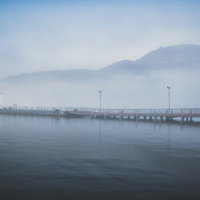 霧に包まれる芦ノ湖の元箱根港の夜明け、朝焼けに染まる桟橋の写真