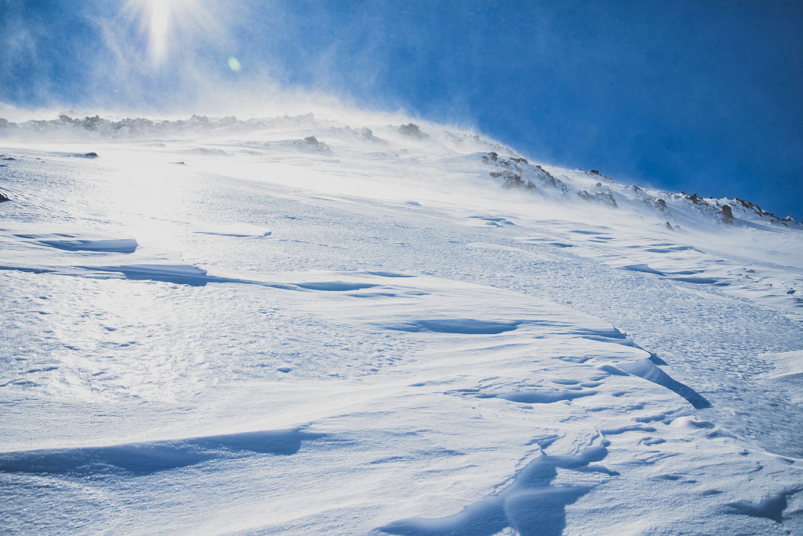 太陽の光を浴びる雪山の斜面