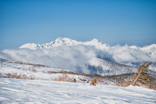雲に巻かれる雪化粧の穂高連峰（飛騨山脈）