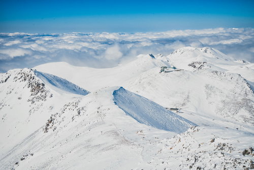 剣ヶ峰山頂から眺める雪化粧の山々と青空