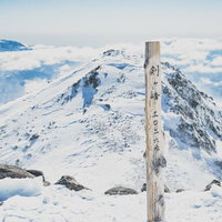 雪に覆われた剣ヶ峰山頂の標識の写真