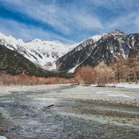 厳冬の穂高連峰と凍結した梓川の雪景色、青空が映える上高地の冬景色の写真