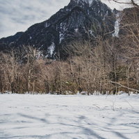 上高地の雪原に伸びる影と六百山、北アルプスの冬景色の写真