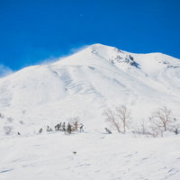 乗鞍高原から望む雪化粧した剣ヶ峰と北アルプスの山並みの写真
