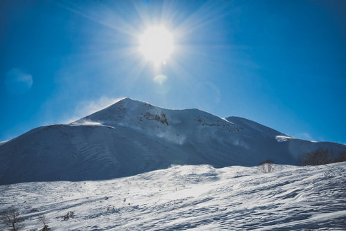 西日の太陽と雪化粧した剣ヶ峰の冬景色