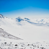 雪で覆われた権現池と雪化粧した冬山の積雪風景の写真