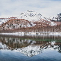 大正池に映る雪化粧の焼岳（飛騨山脈）の冬景色の写真