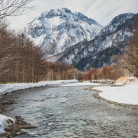 冬の梓川から望む雪化粧した焼岳と雪山の風景の写真