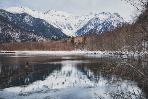 水面に反射した雪化粧の穂高連峰と大正池の冬景色