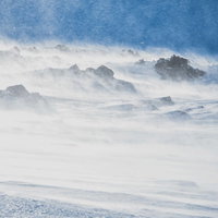 冬山に舞い上がる雪煙、青空に映える雪化粧の絶景の写真