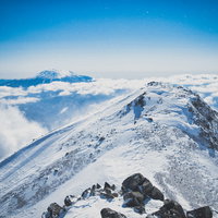 雪化粧した薬師岳と御嶽山が雲海に浮かぶ冬山風景の写真