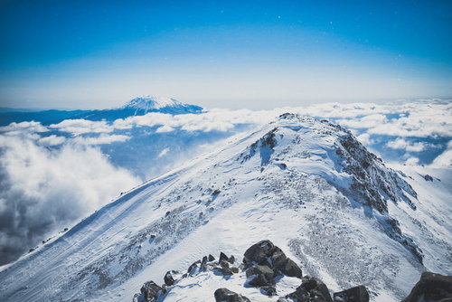 雪化粧した薬師岳と御嶽山が雲海に浮かぶ冬山風景