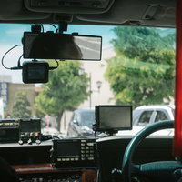 タクシーの後部座席から見た車内と前方の街並みの写真