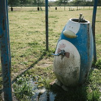 野球場の側にある廃れたペンギンオブジェの水道の写真