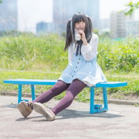 公園のベンチで紙コップを飲む女の子の写真