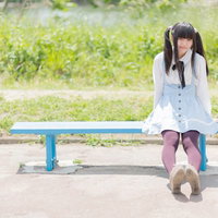 青いベンチに座るツインテールの女の子の写真