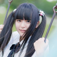 ブランコの鎖をつかむツインテールの女の子の写真