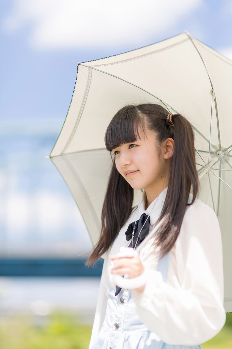 海辺で白い日傘をさす制服姿の女の子［モデル：こころ］