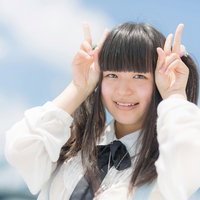 ピースサインで笑顔のツインテールの女の子の写真