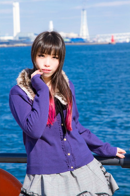 みなとみらいの海を背景にポーズをとる女性