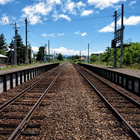 JR富良野線千代ヶ岡駅のホームから青空に続く線路の写真