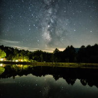 タカソメキャンプ場の釣池に映る天の川と満天の星空の写真