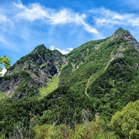上高地から見上げる明神岳の新緑と青空の写真