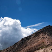 乗鞍剣ヶ峰の登山道に沸く積雲と青空の風景の写真