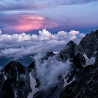 夕焼けに赤く染まる前穂高岳と雲海の写真