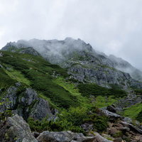 雲がかかる前穂高岳（標高3019メートル）の登山道の写真
