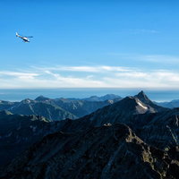 登山道から望む北アルプスの上空を飛ぶヘリコプターの写真