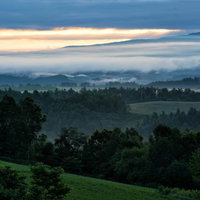 北海道の高台から見る朝焼けと朝霧に包まれた山々の風景の写真