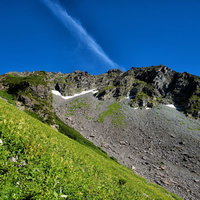 北穂高岳の険しい岩壁に見える青空と岩稜の登山道の写真