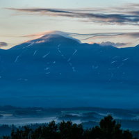 夕暮れの十勝岳にかかる笠雲と山脈の絶景の写真