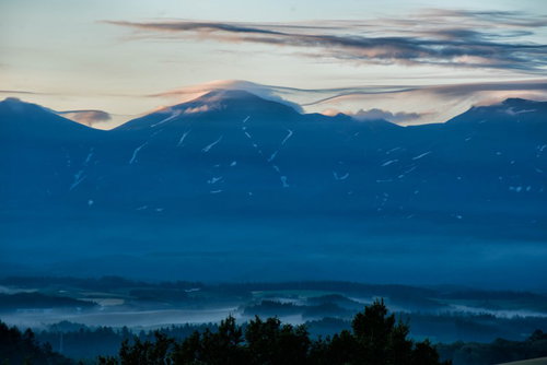 夕暮れの十勝岳にかかる笠雲と山脈の絶景