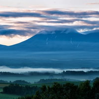 朝霧たちこめる山と池の静寂の写真