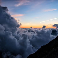 夕暮れに山の稜線から沸き上がる積雲の雲海風景の写真